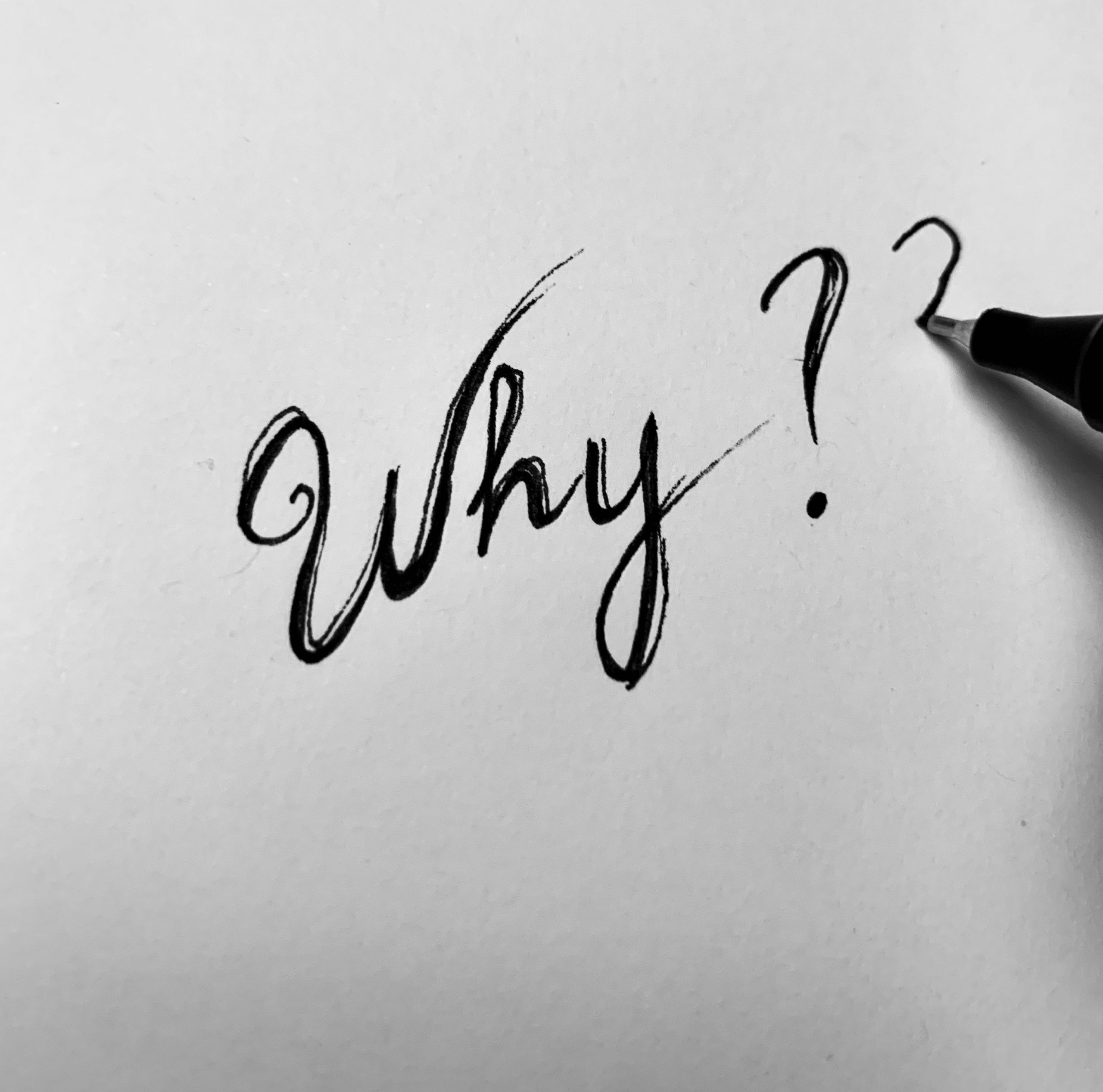 Blank piece of paper with the question "why?" written on it in pen