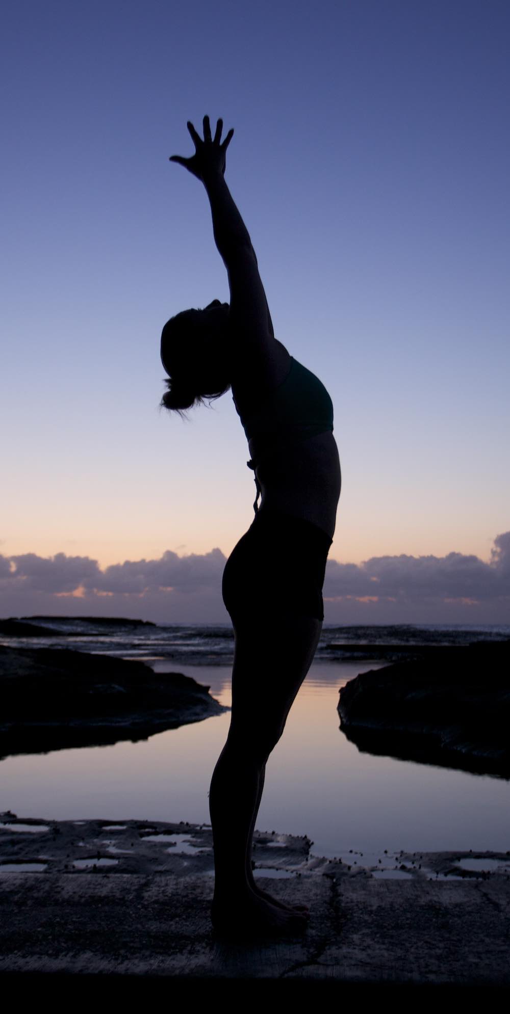 Woman doing yoga for stress at sunrise