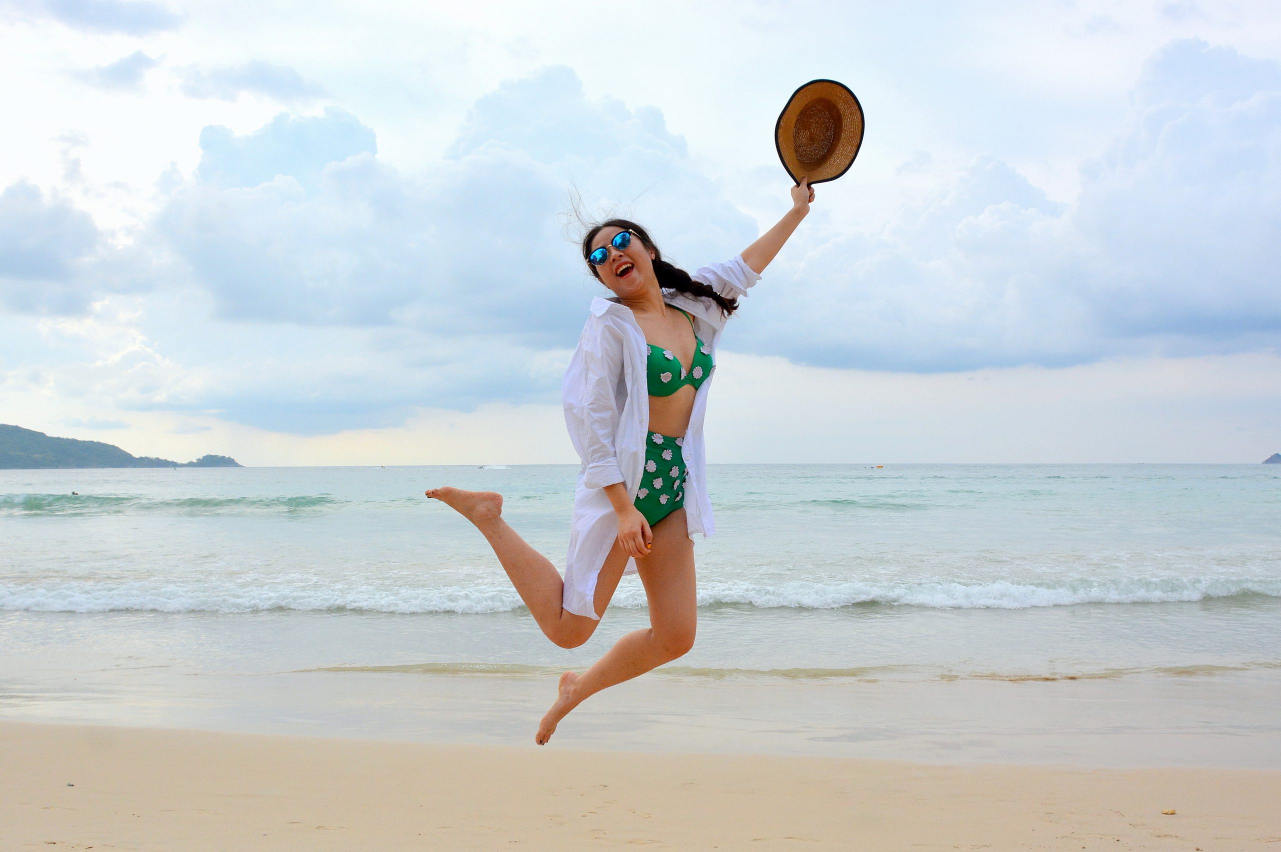 Woman jumping happily on the beach