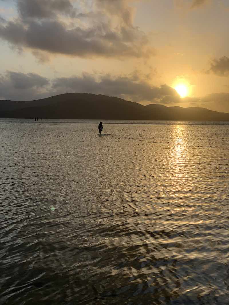 Woman standing in a lake at sunset